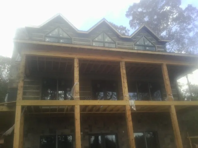 Dormers and porch framing on a large log home under construction — Roof Coating work by our crew in Leesport