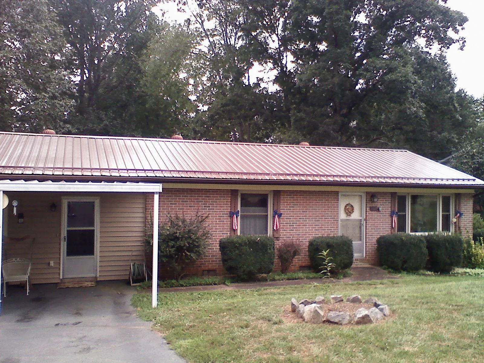Bronze metal roof and carport on a brick ranch home — Roof Repair work by our crew in Leesport